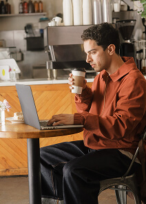 Homem trabalhando e tomando café